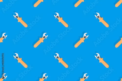 Wrench on a blue background. Seamless background from adjustable metal wrench. Seamless patterns.