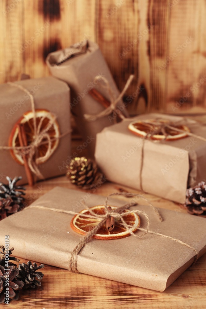 Gifts for Christmas and New Year. packed craft gifts with cinnamon and orange for decoration. Gifts for Christmas and New Year. packed craft gifts with cinnamon and orange for decoration.