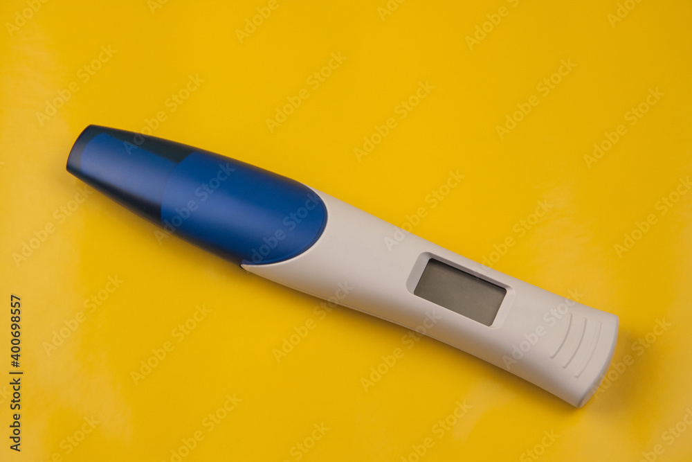 Pregnancy test with a digital display on a yellow background