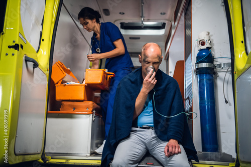 Ambulance car, a young nurse is checking her medical kit to provide the first aid to her patient.