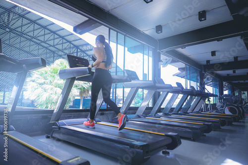 Fit woman running in machine treadmill at fitness gym 