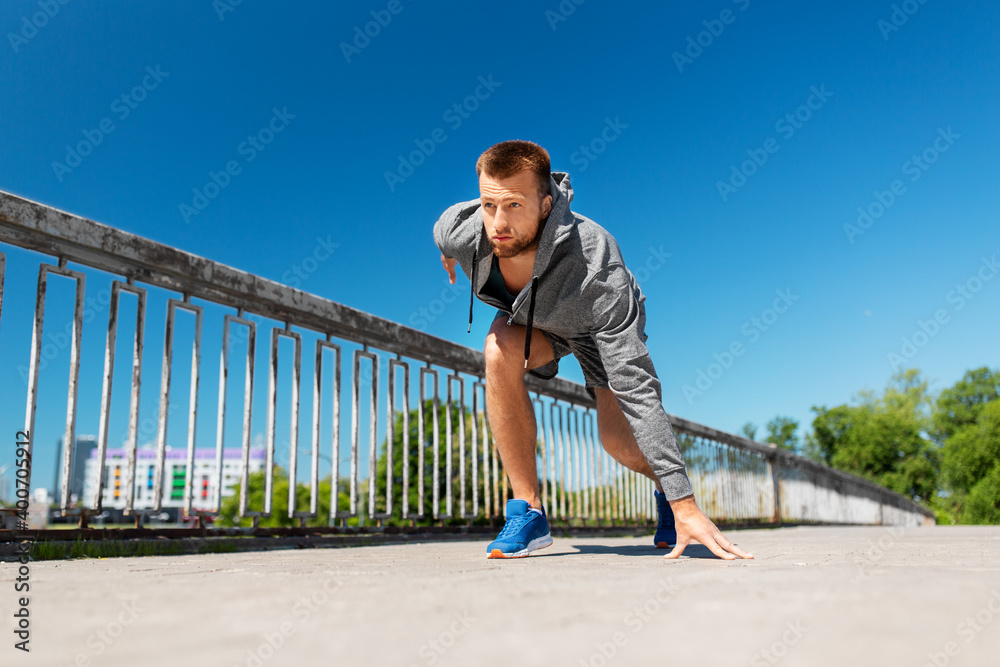 fitness, sport and healthy lifestyle concept - young man running across city bridge