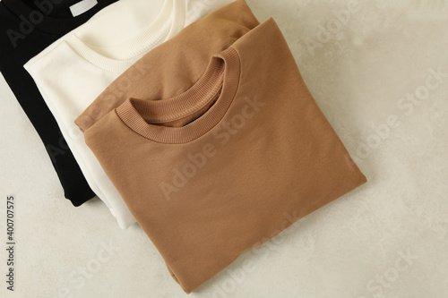 Photos Stylish folded sweatshirts on white background, top view