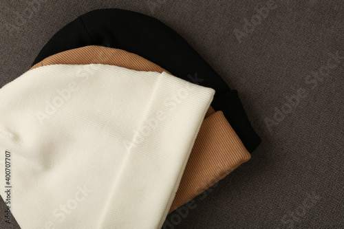 Tableau sur toile Three stylish beanies on cloth background, close up