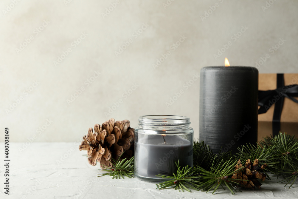Scented candles, gift box and pine branches with cones on white table - obrazy, fototapety, plakaty 