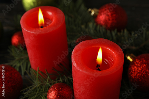 Red candles, baubles and pine branches, close up
