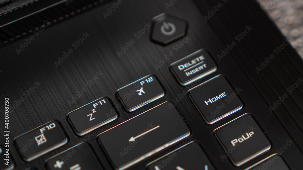 Flight mode button, F12 key, airplane button on keyboard. Laptop flat profile backlit keyboard airplane flight mode key closeup Flight mode button, F12 key, airplane button on keyboard. Laptop flat profile backlit keyboard airplane flight mode key closeup