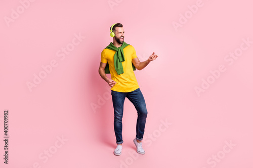 Full size photo of charming happy man play imagine guitar listen music wear jeans isolated on pink color background