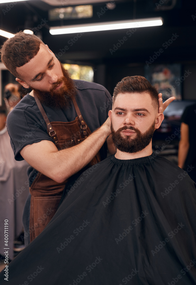 Male barber showing haircut to client Male barber showing haircut to client