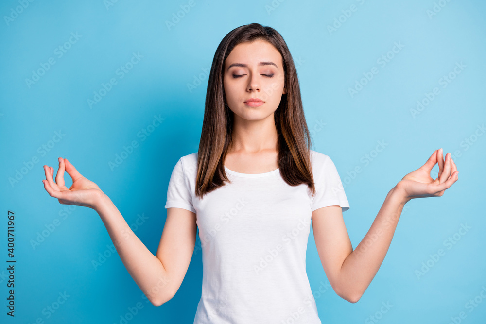 Photo of young peacefull calm sweet lovely cute girl meditating enjoying free time isolated on blue color background Photo of young peacefull calm sweet lovely cute girl meditating enjoying free time isolated on blue color background