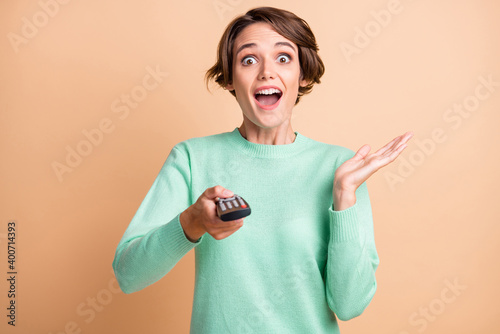 Obraz na płótnie Photo of young attractive woman amazed excited shocked news watch tv hold remote