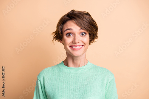 Portrait of young beautiful smiling cheerful excited good mood girl in sweater look camera isolated on beige color background