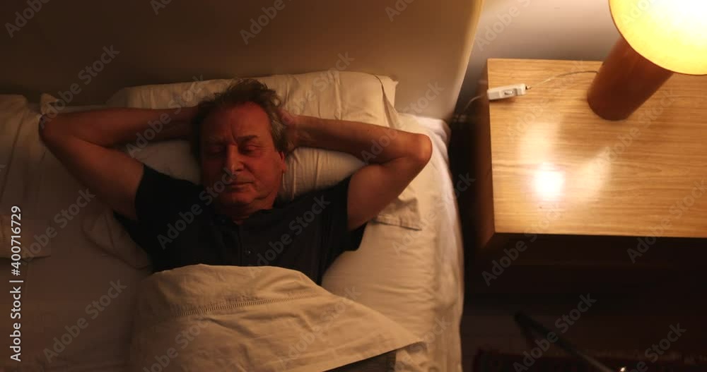 Person suffering from insomnia, old man unable to sleep, wakes in the middle of the night Person suffering from insomnia, old man unable to sleep, wakes in the middle of the night