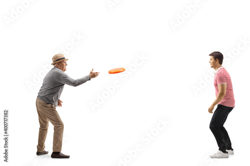 Elderly man throwing a plastic disk with a younger man