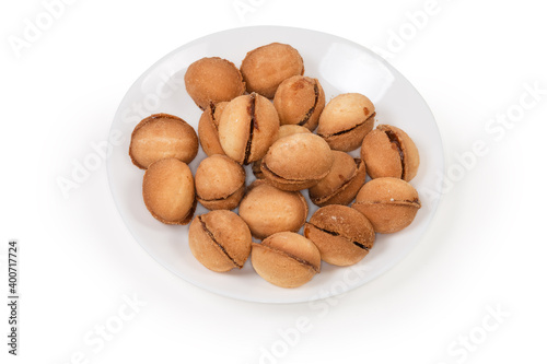 Cookies in shape of nuts with caramel filling on dish