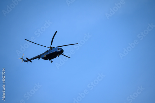 Flying big blue helicopter with blue sky in the background.