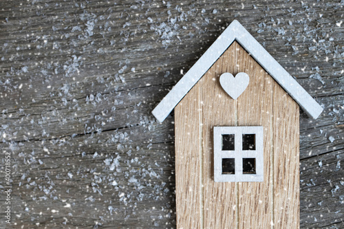 Model of a small wooden house on a natural wooden background.