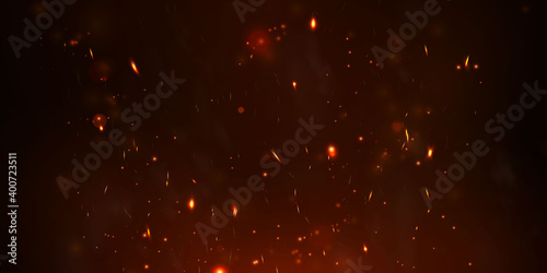 Sparks fly up Glowing particles on a black background and with flames