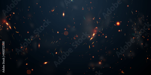 Leinwand Poster Sparks fly up Glowing particles on a black background and with flames