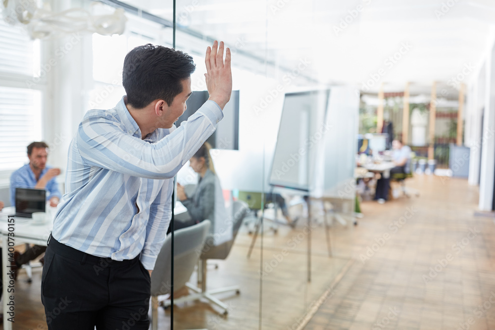Young business man waves to a colleague Young business man waves to a colleague