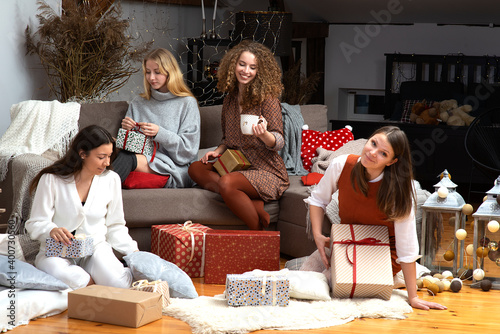 group of young attractive women have fun packing wrapping Christmas presents in a cozy home atmosphe