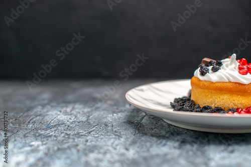 Fotografía front view little delicious cake with chocolate and raisins on light-dark backgr