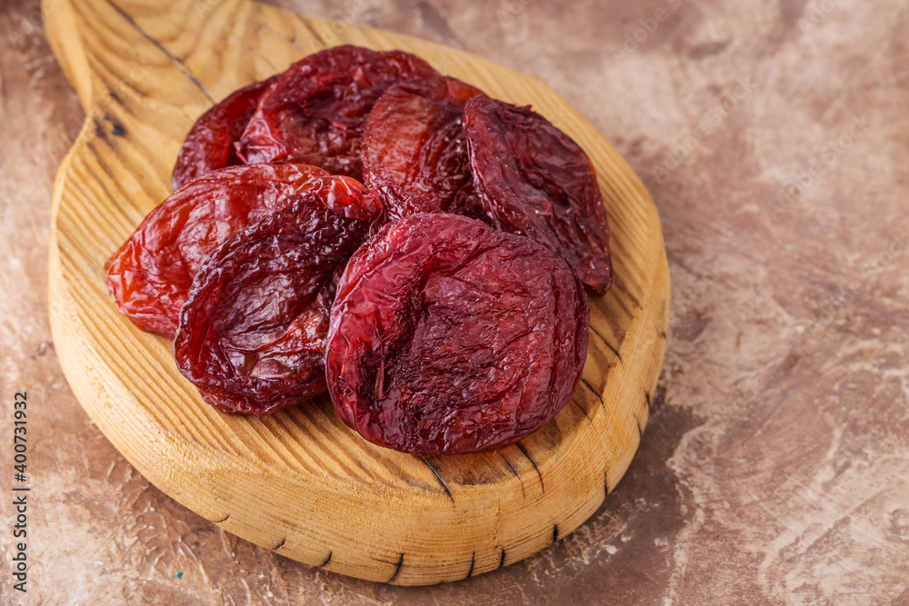 Obraz premium Dried apricots on wooden board, brown background, healthy concept.