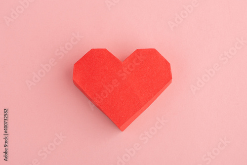 Red paper heart on pink background, top view