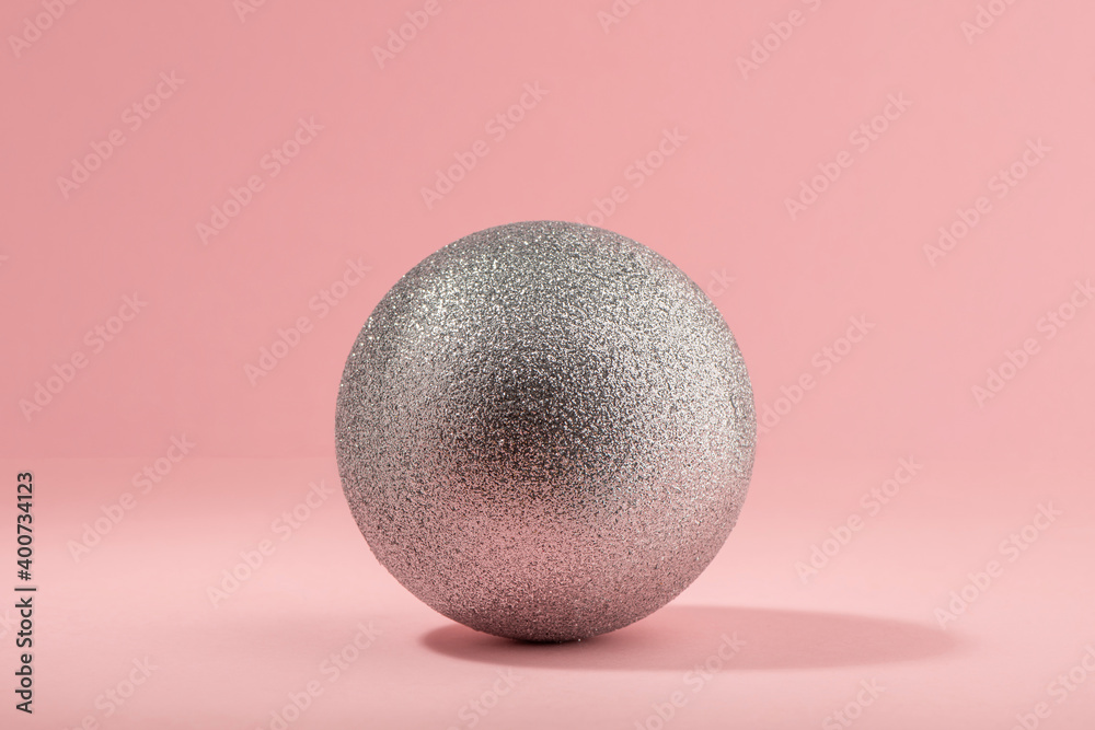 Silver glitter ball on light pink background Silver glitter ball on light pink background