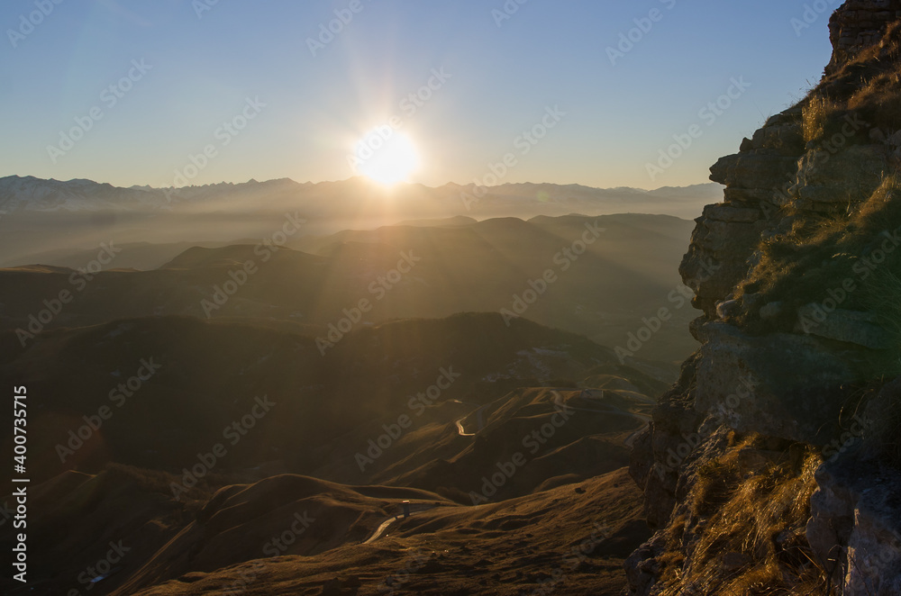 A bright sunset among the mountains. The lights of a sun. Location Gum-Bashi, Karachay-Cherkessia