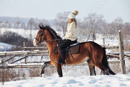 Horse and equestrian model girl in winter snow woods 