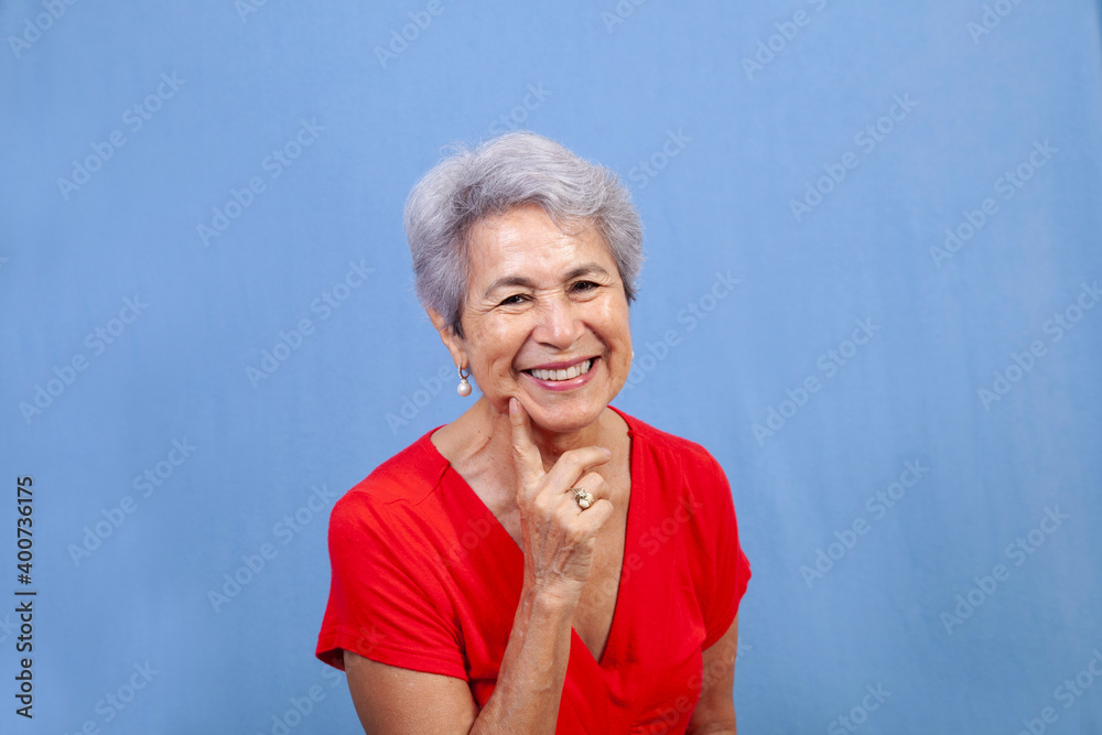 Attractive senior Hispanic woman smiling and finger to chin. Attractive senior Hispanic woman smiling and finger to chin.