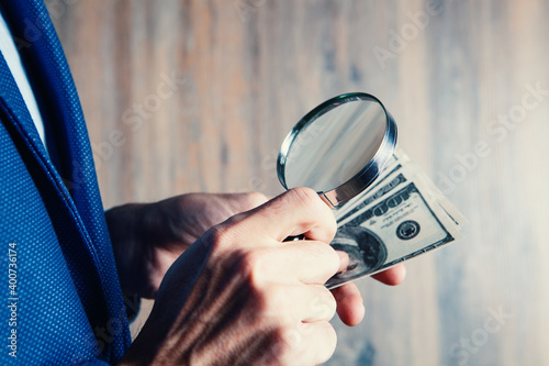 businessman holding a magnifying glass and wallet