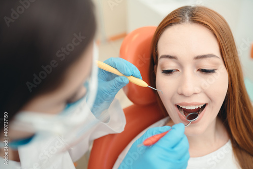 Examination of the patient s teeth by a doctor using a dental mirror