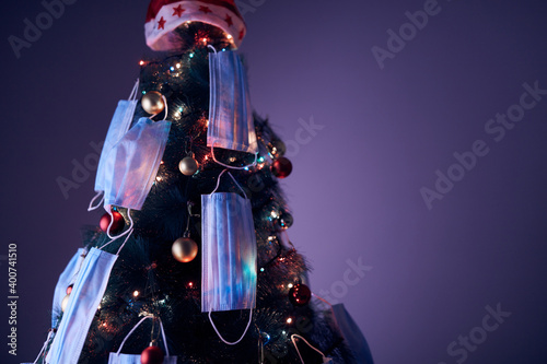 Christmas tree decorated with surgical masks - illustration to virus pandemic 2020 / 2021 social distance, lockdown and quarantine isolation. photo