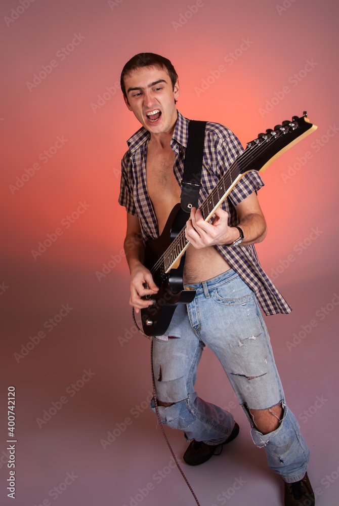 Young guitarist play music on his electric guitar with bright emotions. Young guitarist play music on his electric guitar with bright emotions.