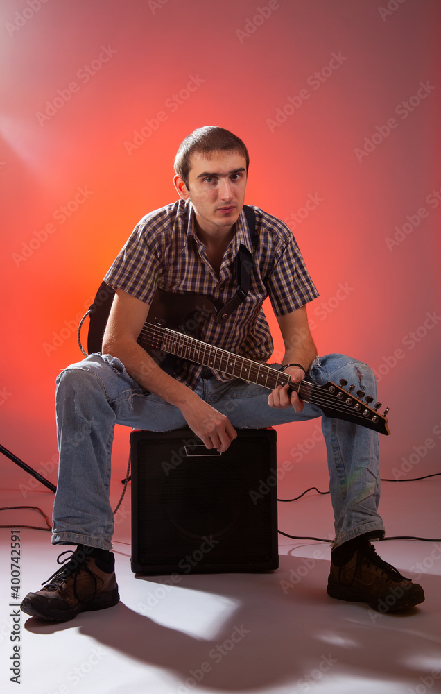 Obraz premium The guitarist play music with combo amplifier in beautiful red hall. 