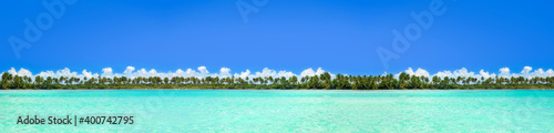 Beautiful view on coconut palms jungle island from sea. Long banner © photopixel