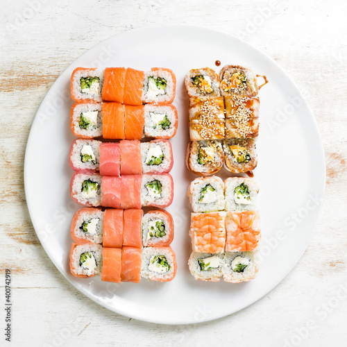 Asian cuisine. Large set of sushi rolls on a plate. Top view. On a white background.