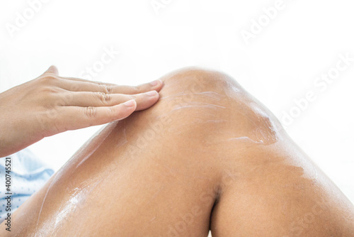 The woman sitting on the ground Use your hands to apply the cream on your legs.