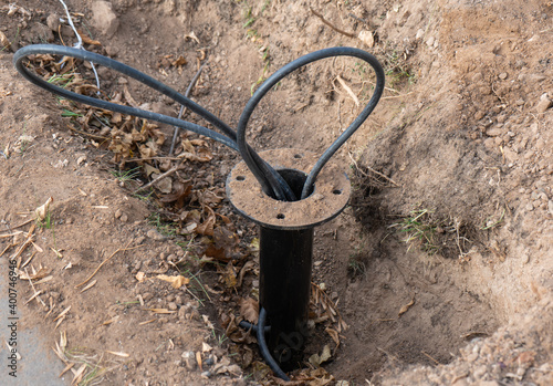 Protruding wires from the ground, the base for a new street lamp. Installation of street lighting