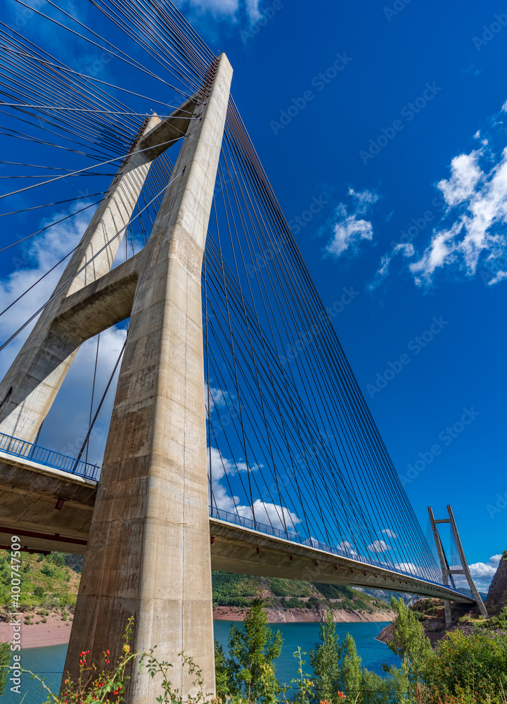 Huge suspension bridge and dam over blue sky, vertical composition Huge suspension bridge and dam over blue sky, vertical composition