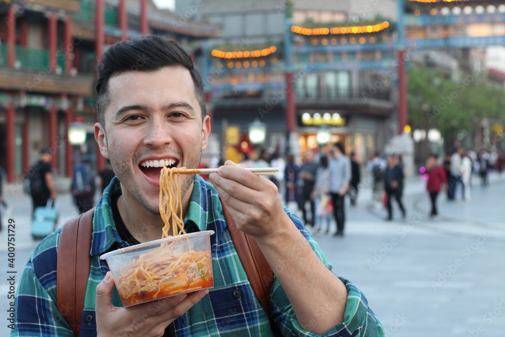 Man enjoying Asian street food  - obrazy, fototapety, plakaty 