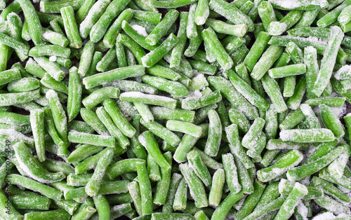 Green beans sliced and frozen. Jadjoyjq background, scattered beans with ice particles. The idea of dinner and a side dish.