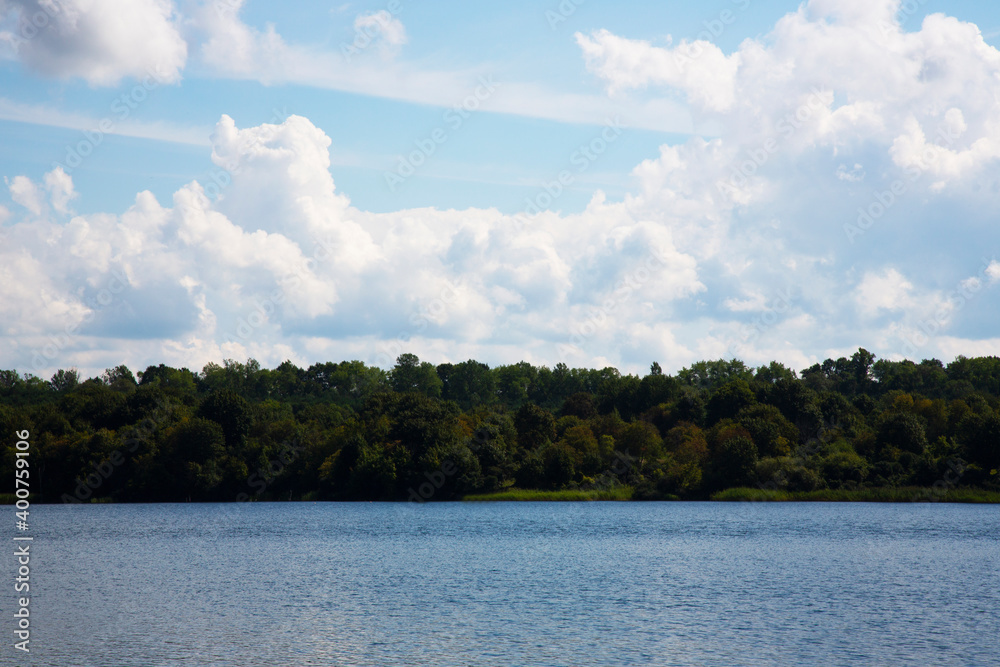 Blue lake blue sky and forest on the shore on a sunny summer day