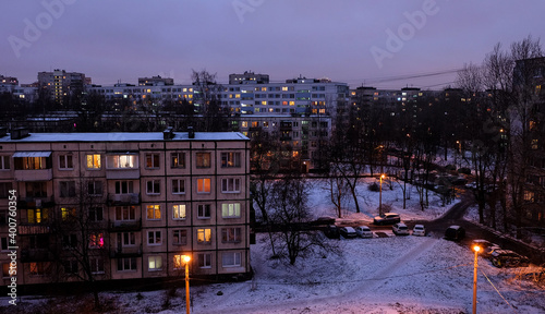 A bedroom community Kupchino district at early twilight. A view above five-story buildings and nine-story buildings with lightened windows.