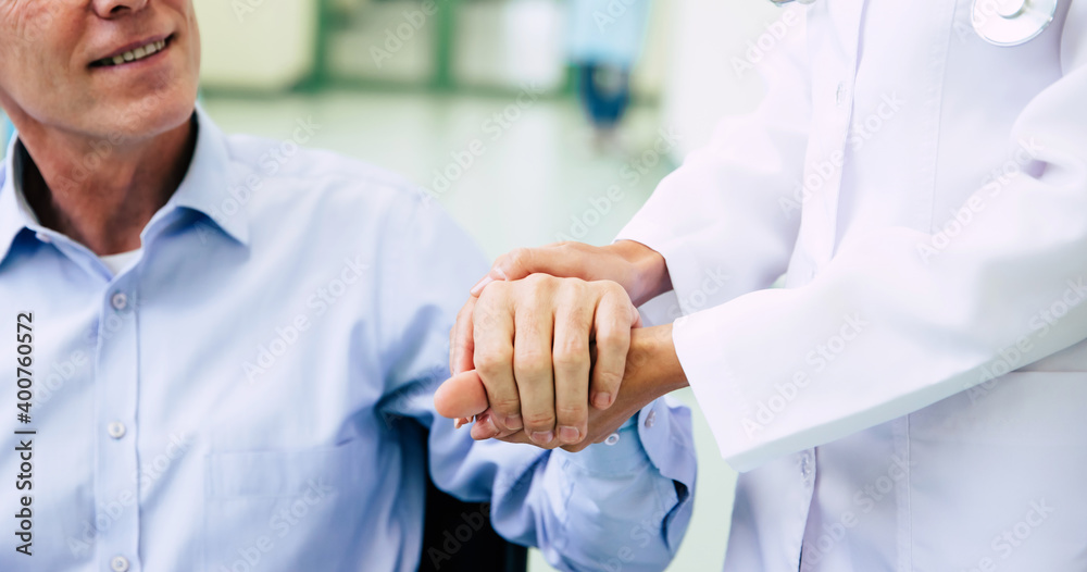 Obraz premium Senior handsome man in a wheelchair is moving in the hospital with help of medical special staff