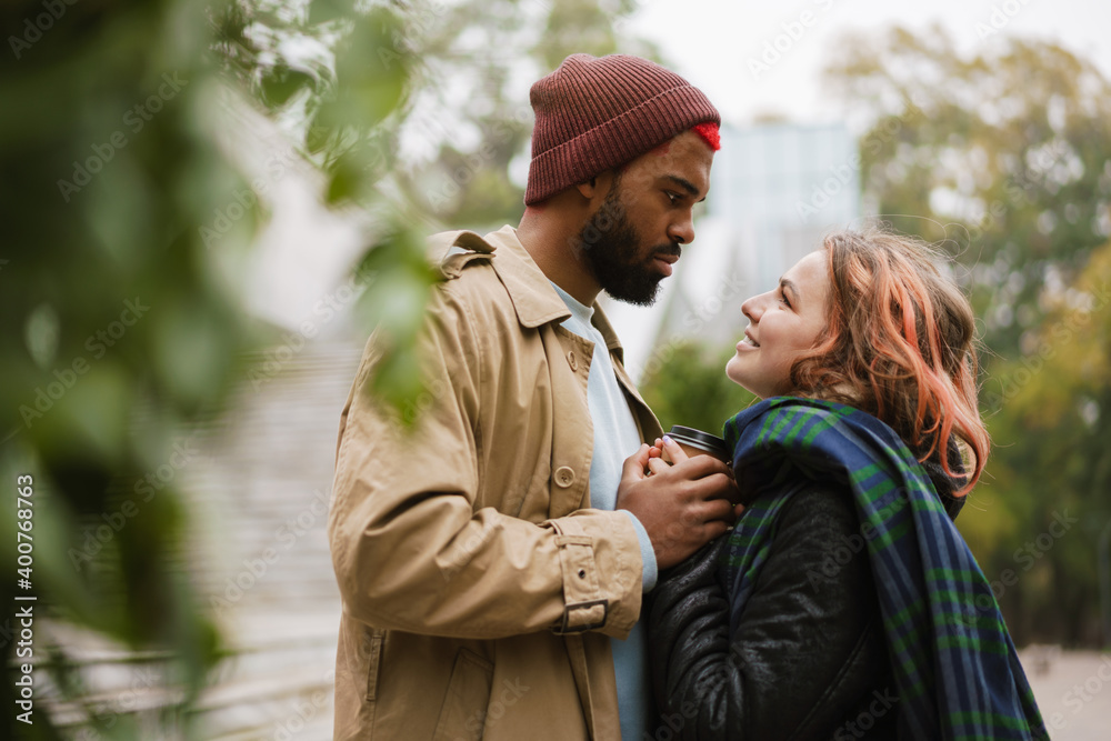 Fototapeta premium Multinational lovely couple looking at each other on city street