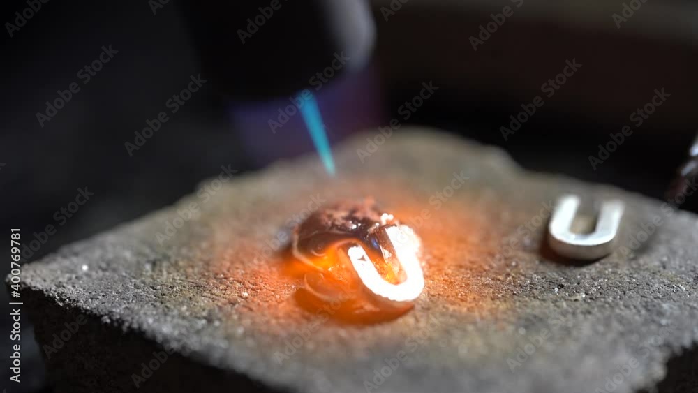 Silver drop melted with gas burner in jewelry workshop