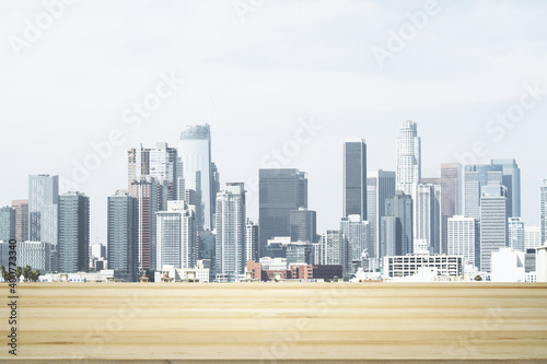 Empty wooden table top with beautiful Los Angeles skyscrapers at daytime on background  mock up